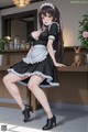 A woman in a maid outfit posing for a picture.