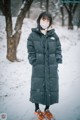 A woman wearing a face mask standing in the snow.