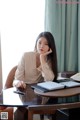 A woman sitting at a table with a laptop computer.