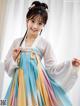 A woman in a colorful hanbok is posing for a picture.