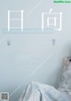 A woman sitting on a bed in front of a blue wall.