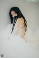 A woman is taking a bath in a bathtub filled with foam.