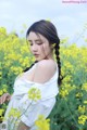 A woman in a field of yellow flowers.