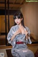 A woman in a kimono sitting on a table.