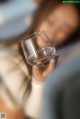 A woman holding a glass of water in her hand.