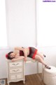 A woman laying on top of a white dresser.